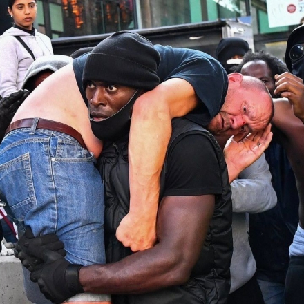 O ativista negro Patrick Hutchinson carrega supremacista branco ferido durante protesto em Londres em 2020